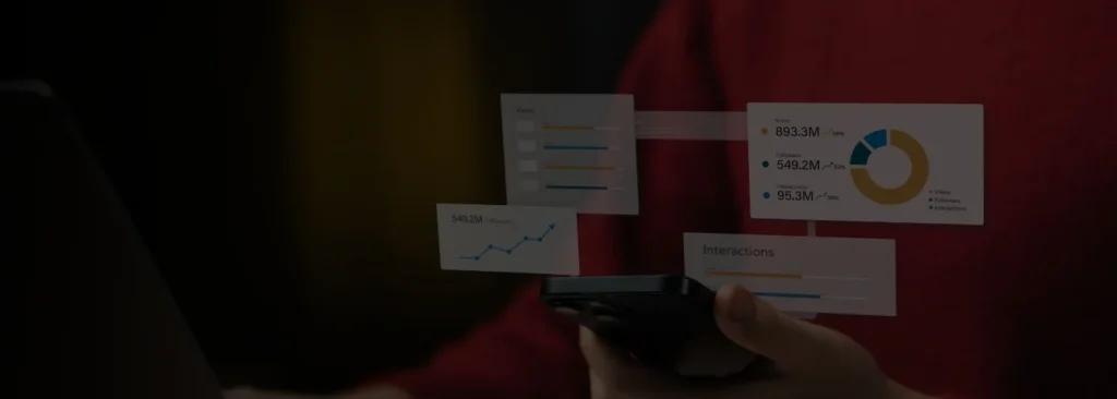 Image of a person holding a smart phone with business graphs floating above the phone.  Dark overlay.